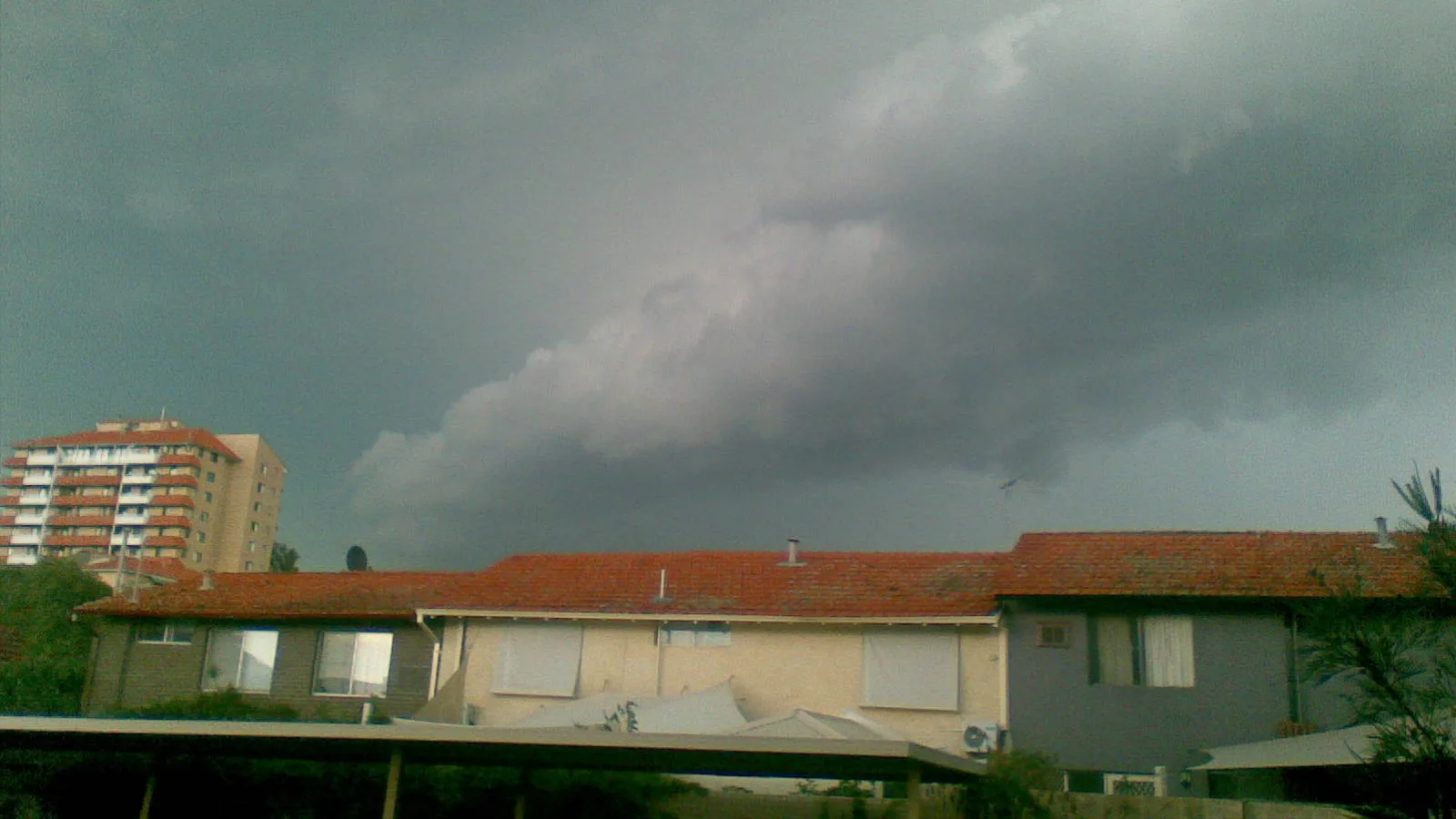 A dark shelf cloud over rooftops during the Perth storm of March 2010